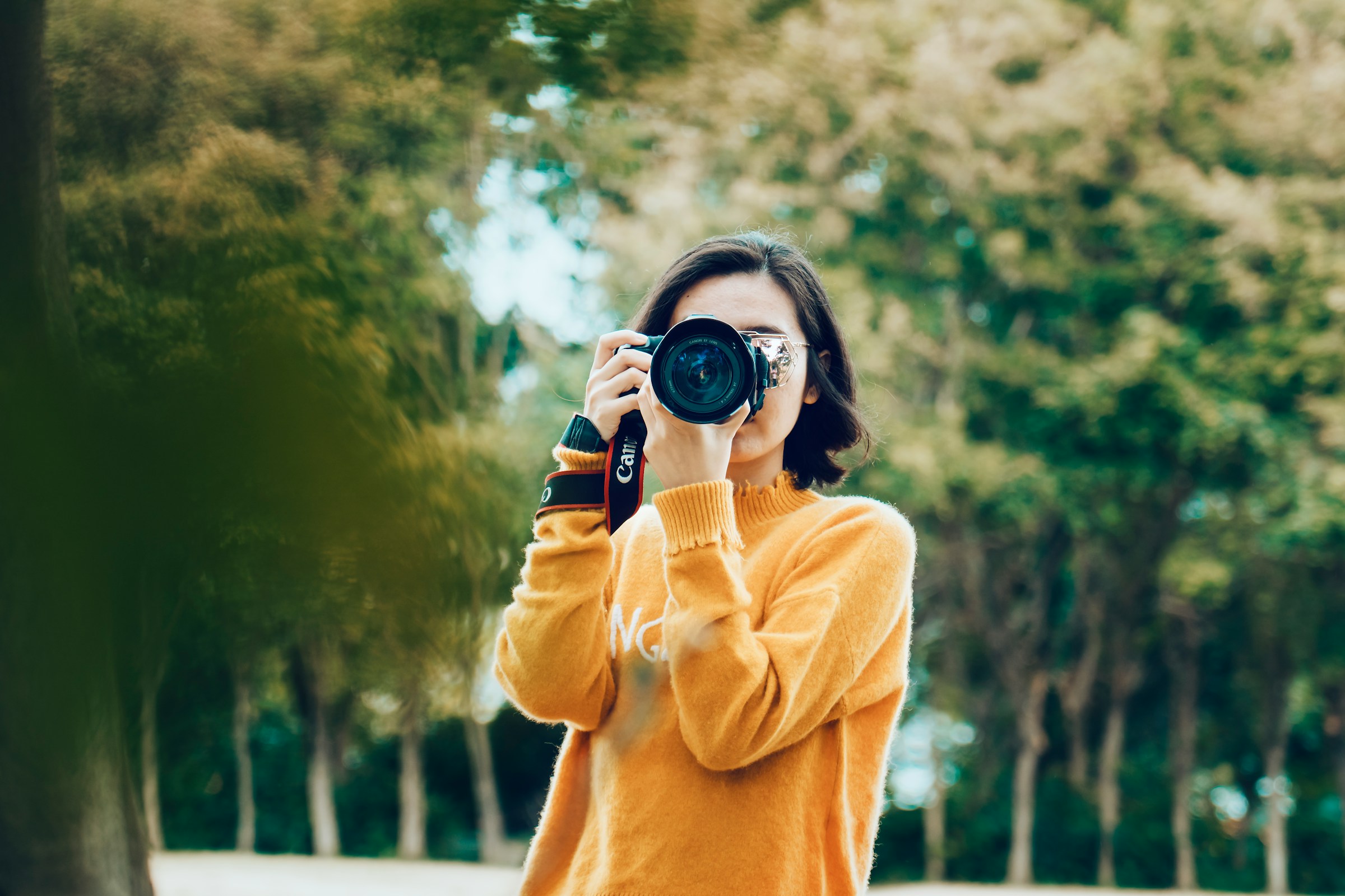 Eine Junge Frau macht ein Foto mit einer Kamera.