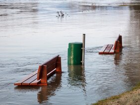 Bank und Mülleimer bei Hochwasser/Flut